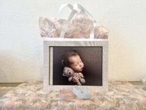 A gift card with a baby holding a stuffed animal as a example of great gift ideas for Mom!