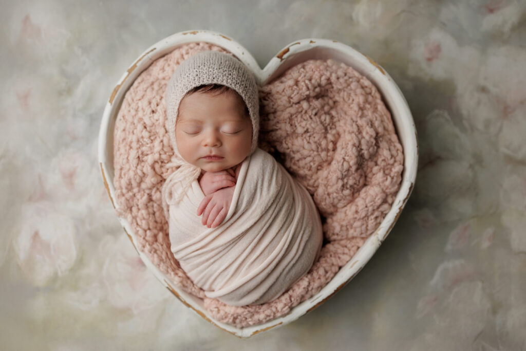 newborn baby inside heart bowl