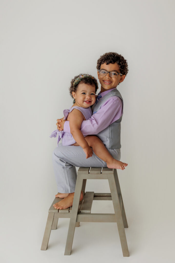two siblings in a photo studio, white background